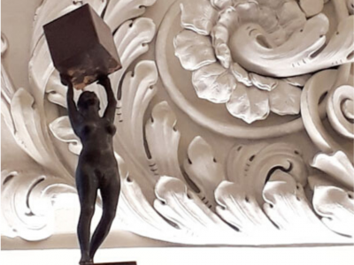 Figur von David Dott stemmt einen Kupferwürfel vor dem mächtigen Stuck im Fembo Haus Stadtmuseum Nürnberg