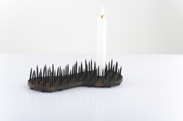 Kerzenleuchter von Anne Fischer, er hat die Form eines Buesserschuhes. Seine Dornen sind Hufnägel