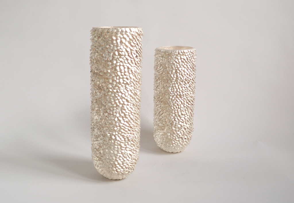 zwei zylindrische Gefäße aus Silber mit einer Oberfläche aus aus vielen kleinen Plättchen