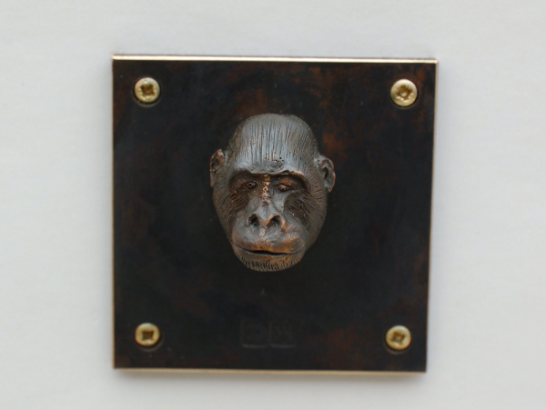 Tierkopf-Affenkopf aus Bronze auf dunkler Platte 5 x 5 cm